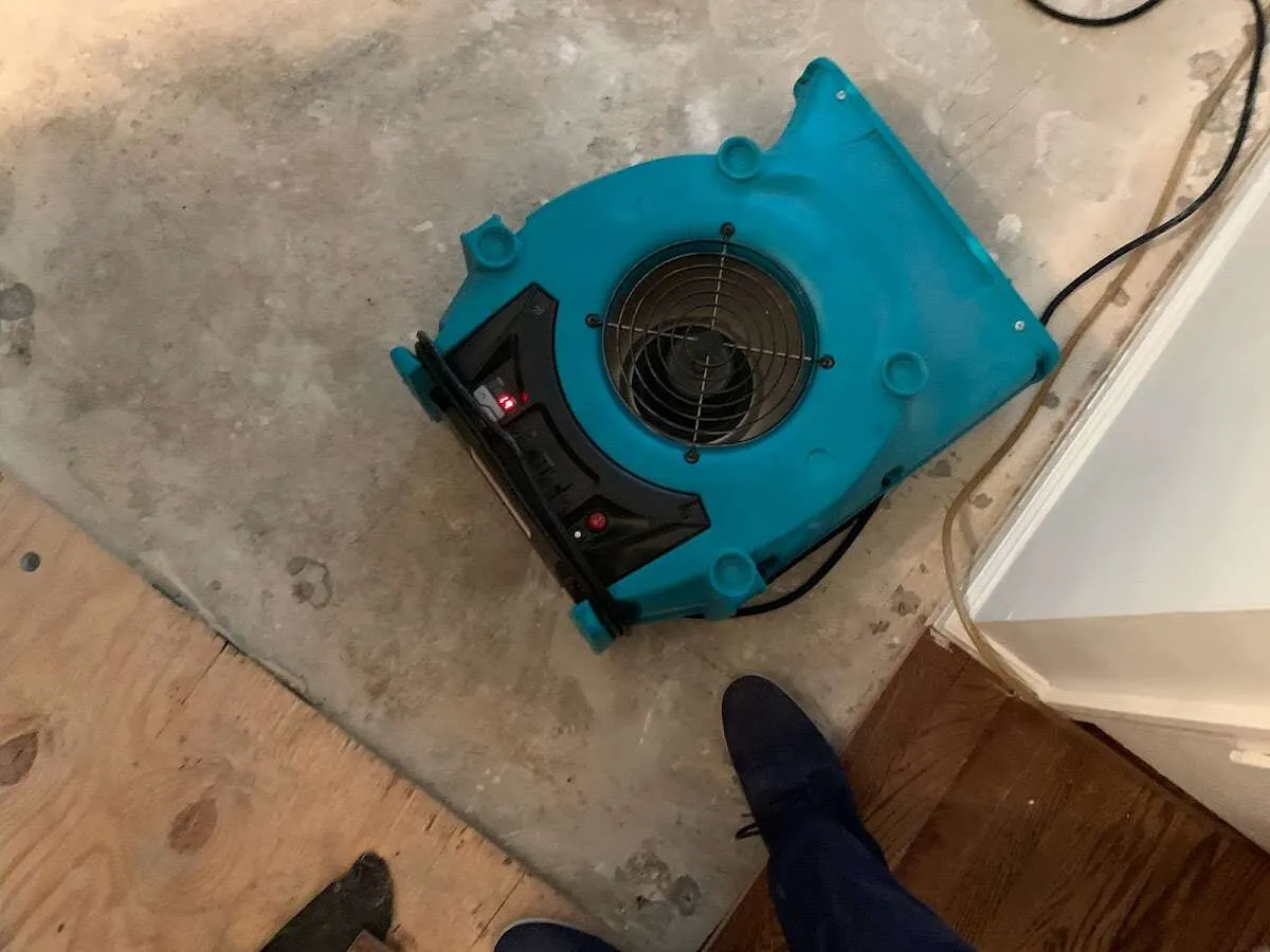 Air mover drying subfloor during Commercial Water Damage Restoration in Becker